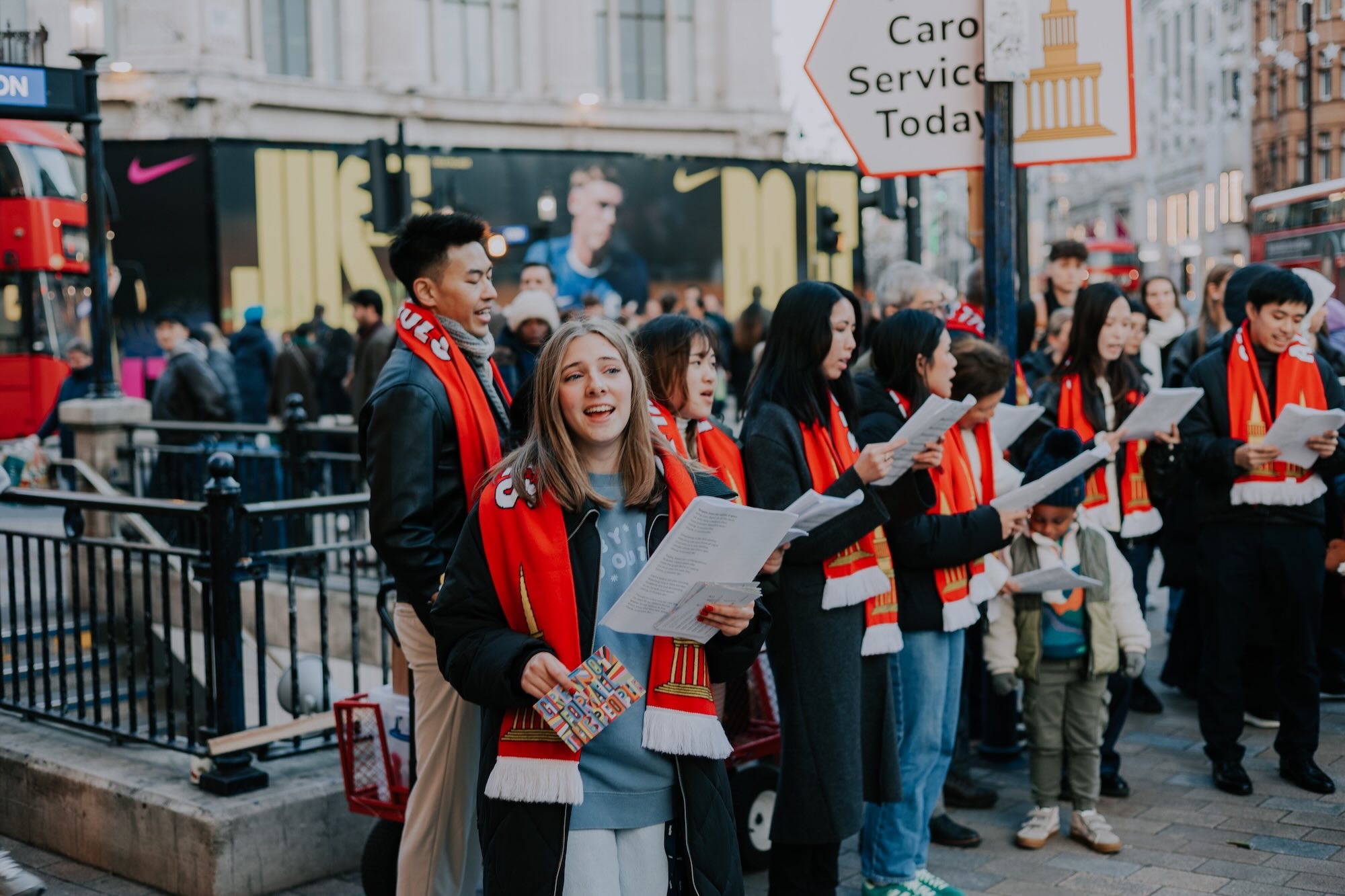 Carol singers at Oxford Circus draw a crowd and point people towards the All Souls carol service.