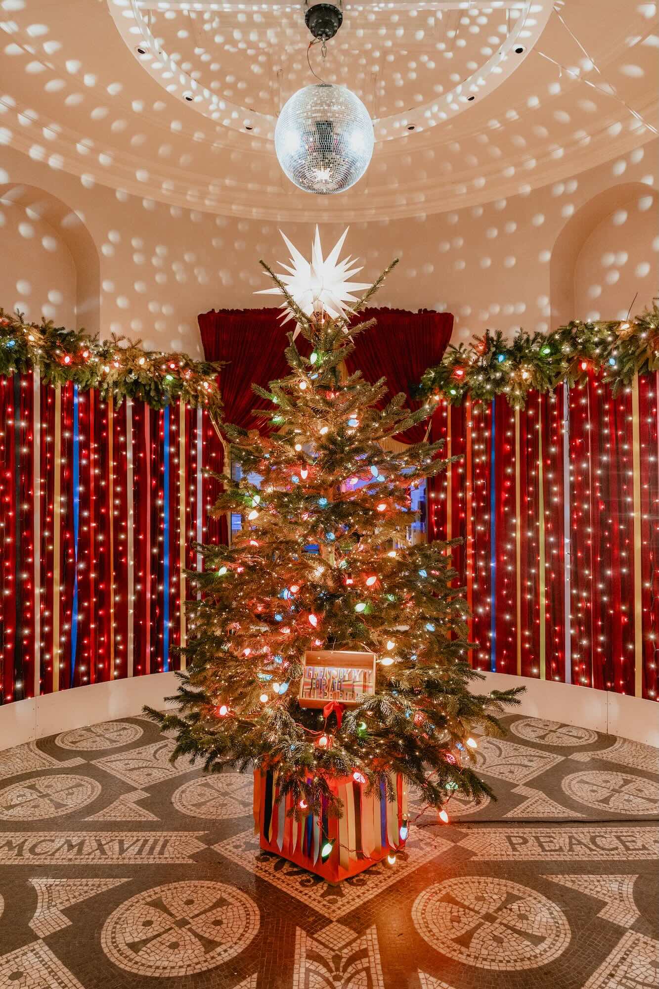 A Christmas tree and glitter ball set a festive, colourful atmosphere as people arrive at All Souls.